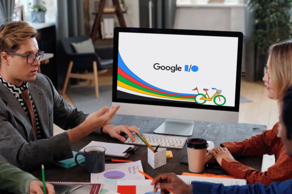 group of people speaking and a computer screen with the google io 2023 logo on it