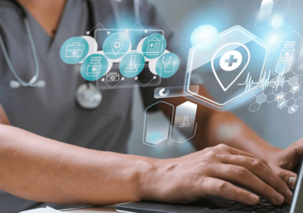 blog header image featuring someone in scrubs using a laptop with icons relating to healthcare iot devices overlaid