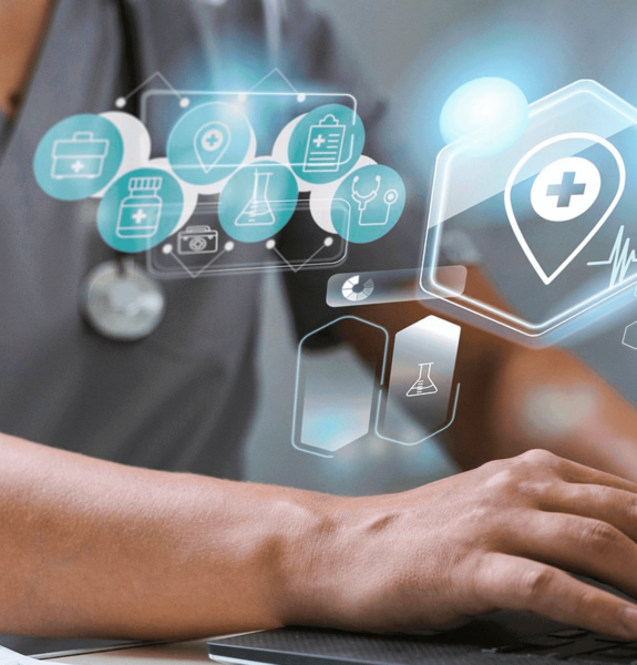 blog header image featuring someone in scrubs using a laptop with icons relating to healthcare iot devices overlaid