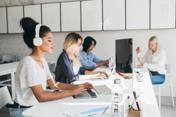 group of diverse women with computers and other technology