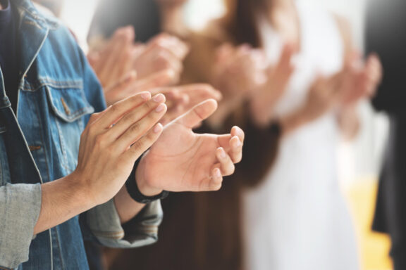 someone wearing jean jacket clapping hands