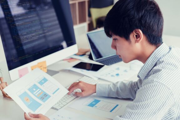 asian man working on designing and coding mvp minimum viable product